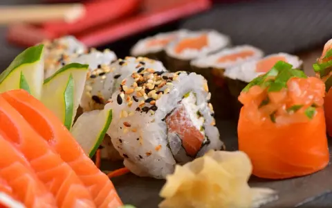 Pyszne sushi z łososiem, ogórkiem i sezamem. Choć ryby morskie zawierają zdrowe tłuszcze, warto pamiętać o umiarkowanym spożyciu, zwłaszcza jeśli dbamy o poziom cholesterolu.