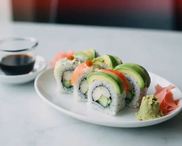 Uramaki california z awokado, krabem i ogórkiem, podane z wasabi i imbirem.
