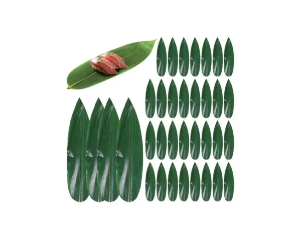 Zielone liście do sushi, jeden z nich ozdobiony dwoma kawałkami nigiri.