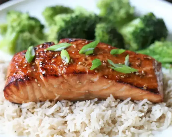 Łosoś w sosie teriyaki na ryżu z brokułami, posypany sezamem i szczypiorkiem. Pyszne danie.
