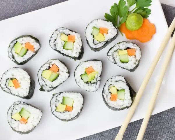 Talerz sushi z awokado, ogórkiem i marchewką. Czy sushi jest kaloryczne? Zależy od składników, ale te warzywne rolki są lekkie!