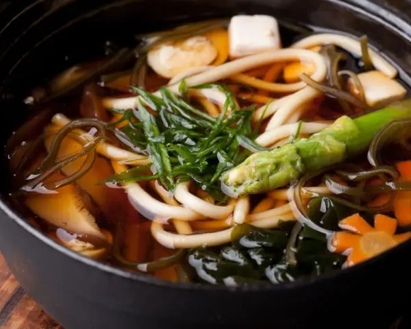 Gęsta zupa z grubym makaronem udon, tofu, warzywami i wodorostami w aromatycznym bulionie dashi.