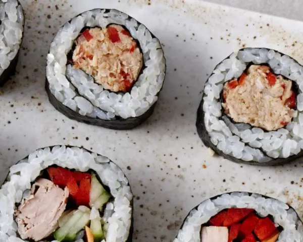 Roladki sushi z ryżem, nori i pyszną pastą z tuńczyka z dodatkiem czerwonej papryki. Idealne na szybką przekąskę.
