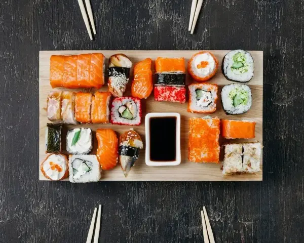 Na desce ułożono różnorodne sushi. Ile kawałków sushi na osobę? Zależy od apetytu, ale jest tu spory wybór!