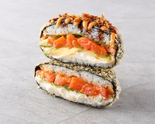 Sushiburger z łososiem, awokado i kremowym serkiem, otoczony chrupiącą panierką z ryżu i nori.