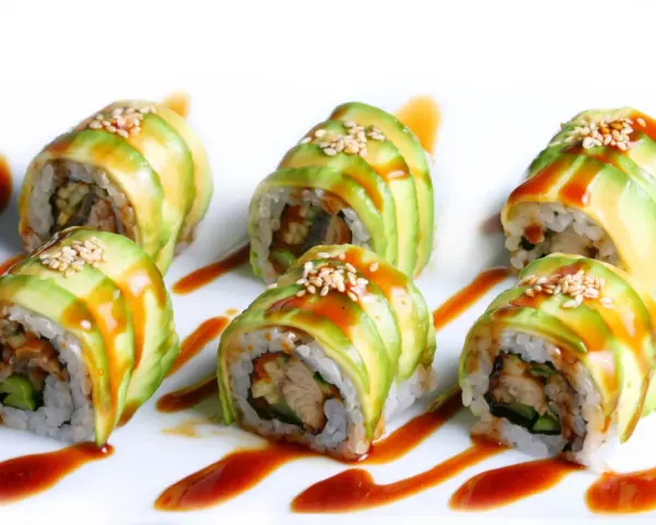Sześć kawałków sushi dragon roll, udekorowanych plastrami awokado, sezamem i sosem.