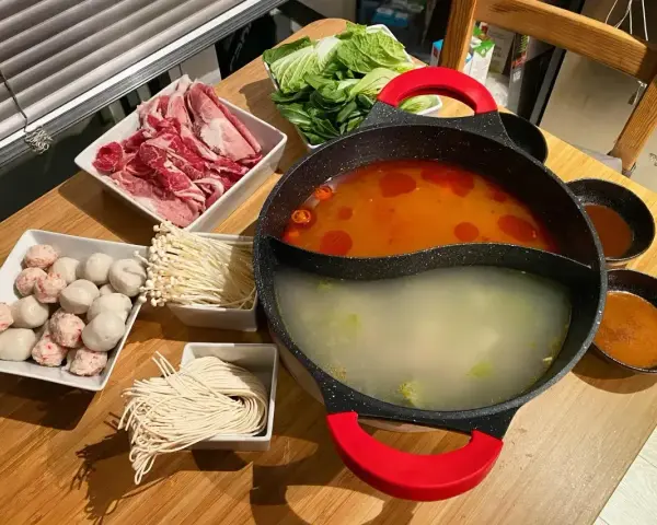 Pyszny **lau thai** z cienko pokrojonym mięsem, kluskami, grzybkami enoki, kulkami rybnymi i warzywami.