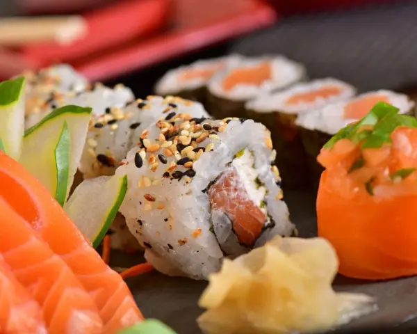 Pyszne sushi z łososiem, ogórkiem i sezamem. Choć ryby morskie zawierają zdrowe tłuszcze, warto pamiętać o umiarkowanym spożyciu, zwłaszcza jeśli dbamy o poziom cholesterolu.