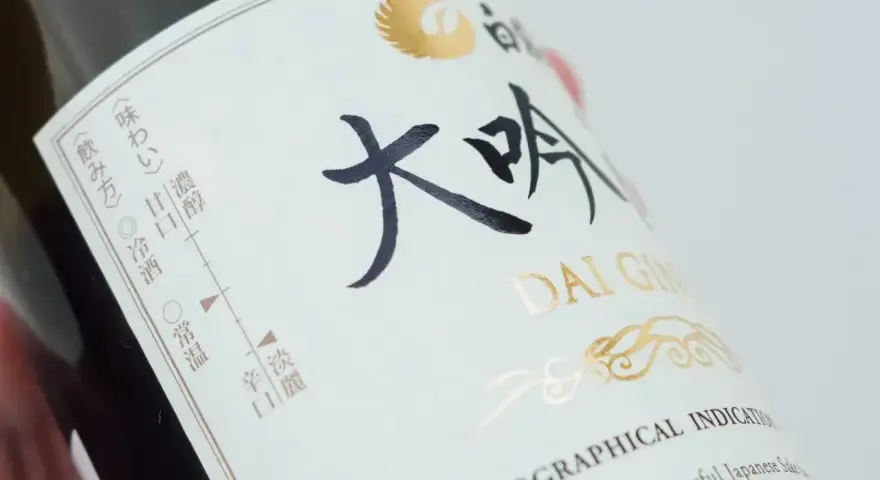Butelka sake Dai Ginjo. Na etykiecie widnieje informacja o zawartości alkoholu, smakach i sposobie podania.