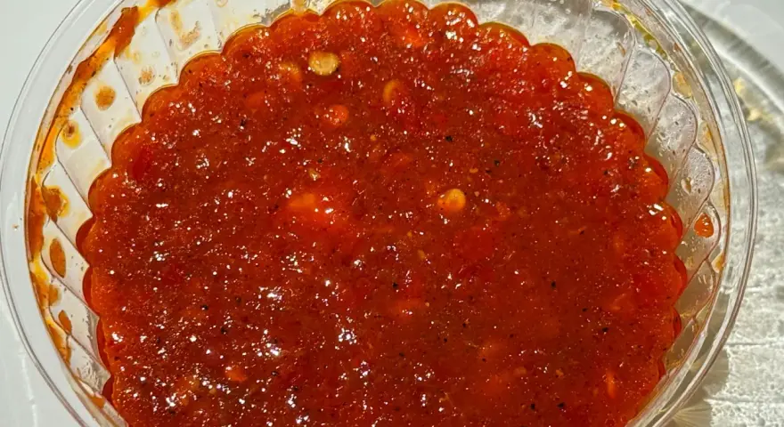 Ostre, czerwone sambal w przezroczystym pojemniku. Idealne do potraw, gdy zastanawiasz się, sambal co to jest i chcesz dodać pikanterii.