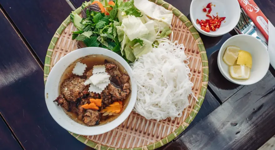 Pyszne bun chay: grillowane mięso, ryżowy makaron, świeże zioła, warzywa, chili i cytryna.