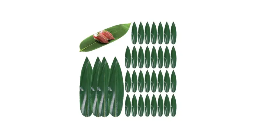 Zielone liście do sushi, jeden z nich ozdobiony dwoma kawałkami nigiri.