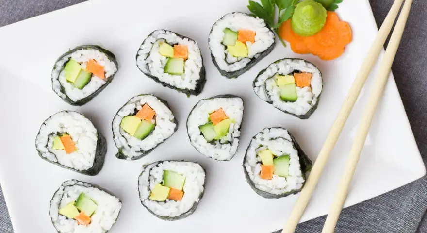 Talerz sushi z awokado, ogórkiem i marchewką. Czy sushi jest kaloryczne? Zależy od składników, ale te warzywne rolki są lekkie!