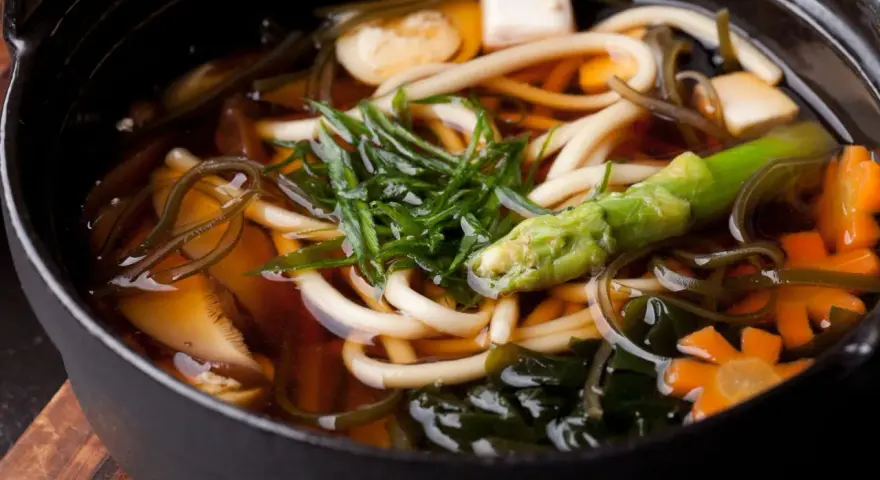 Gęsta zupa z grubym makaronem udon, tofu, warzywami i wodorostami w aromatycznym bulionie dashi.
