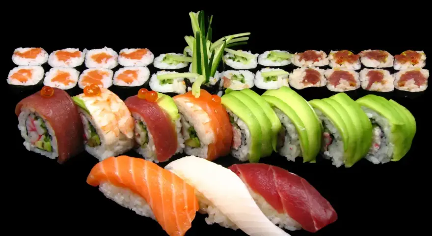 Różnorodne sushi: nigiri z łososiem, tuńczykiem i kalmarem, rolki z awokado, krewetką, tuńczykiem i krabem. Idealne na początek przygody, jak jeść sushi.