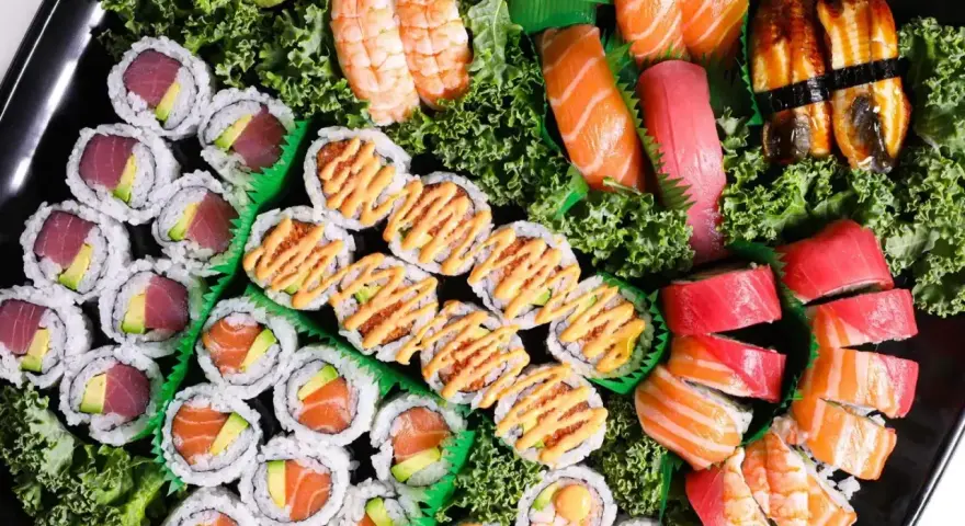 Taca pełna sushi z Japonii: rolki z tuńczykiem i awokado, łososiem, krewetkami, nigiri z łososiem, tuńczykiem i węgorzem.