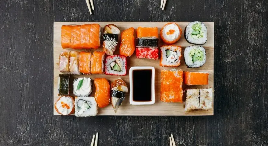Na desce ułożono różnorodne sushi. Ile kawałków sushi na osobę? Zależy od apetytu, ale jest tu spory wybór!