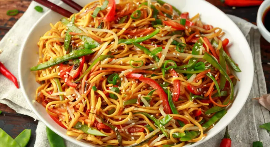 Miseczka makaronu chow mein z warzywami i pałeczkami.