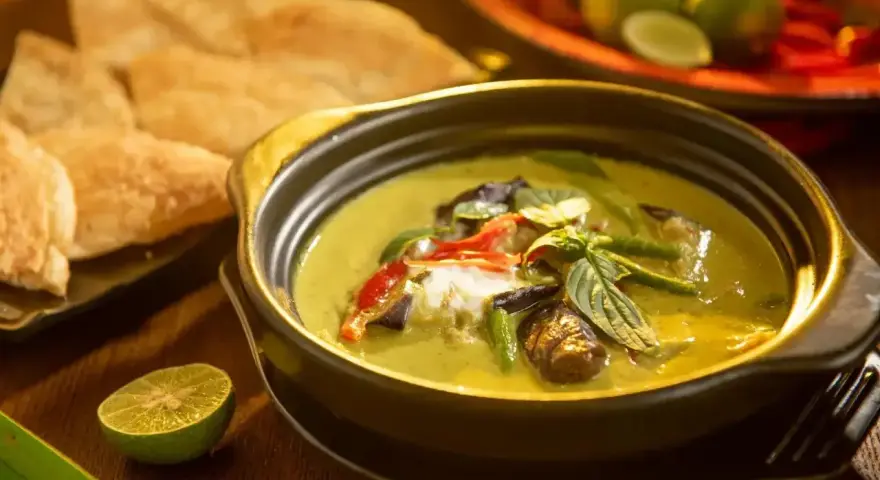 Zielone curry z bakłażanem i papryką, podane z chlebkiem naan i limonką. Jedne z wielu pysznych rodzajów curry.
