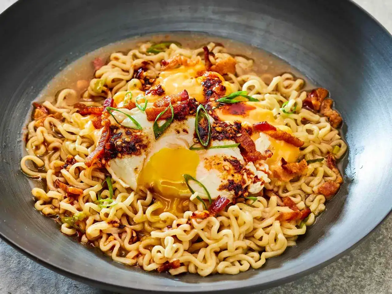 Pyszne ramen z boczkiem, jajkiem sadzonym i szczypiorkiem. Idealne na szybki i sycący posiłek.