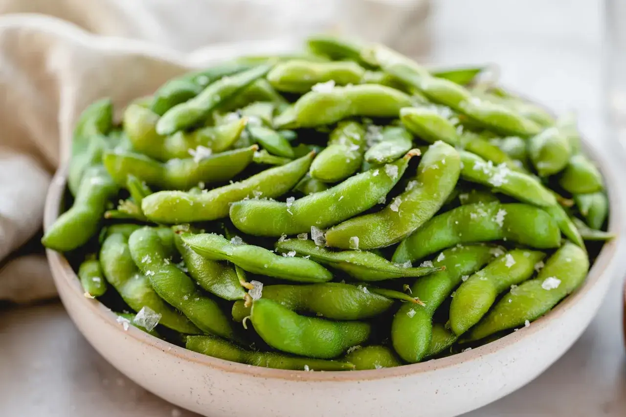 Miseczka pełna zielonej, lekko posolonej fasolki edamame, gotowej do chrupania.
