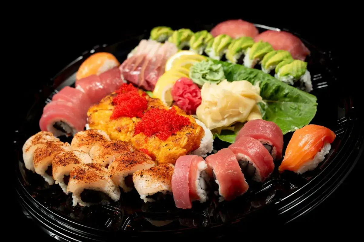 Talerz sushi z różnymi rolkami, nigiri i sashimi. Wyobraź sobie, jak smakuje sushi, gdy widzisz te świeże składniki.
