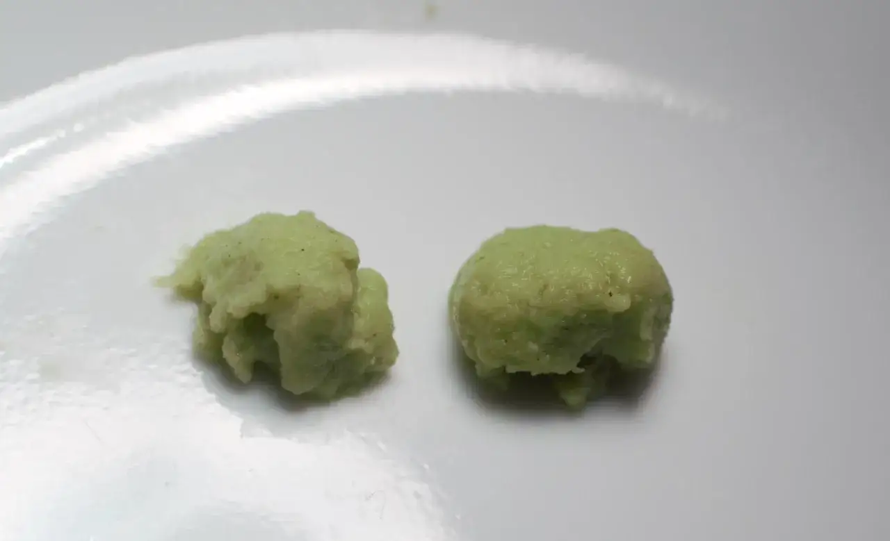 Dwie porcje zielonego wasabi na białym talerzu. Czy wasabi jest zdrowe? Tak, zawiera związki o właściwościach antybakteryjnych.