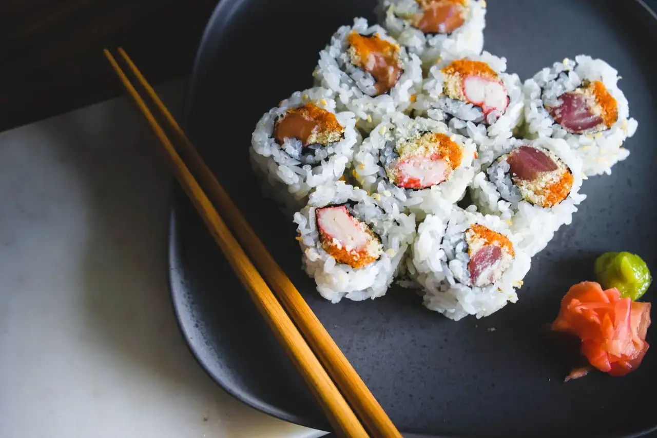 Talerz z sushi, pałeczki i dodatki. Idealne na spokojny wieczór, nawet gdy nori w ciąży marzy o smacznych kąskach.