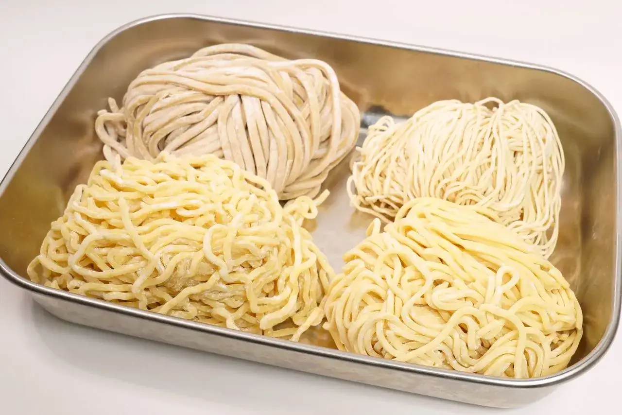 Cztery rodzaje makaronu do ramen w metalowej tacce: grubszy, cieńszy, falowany i prosty. Jaki makaron do ramen wybrać?