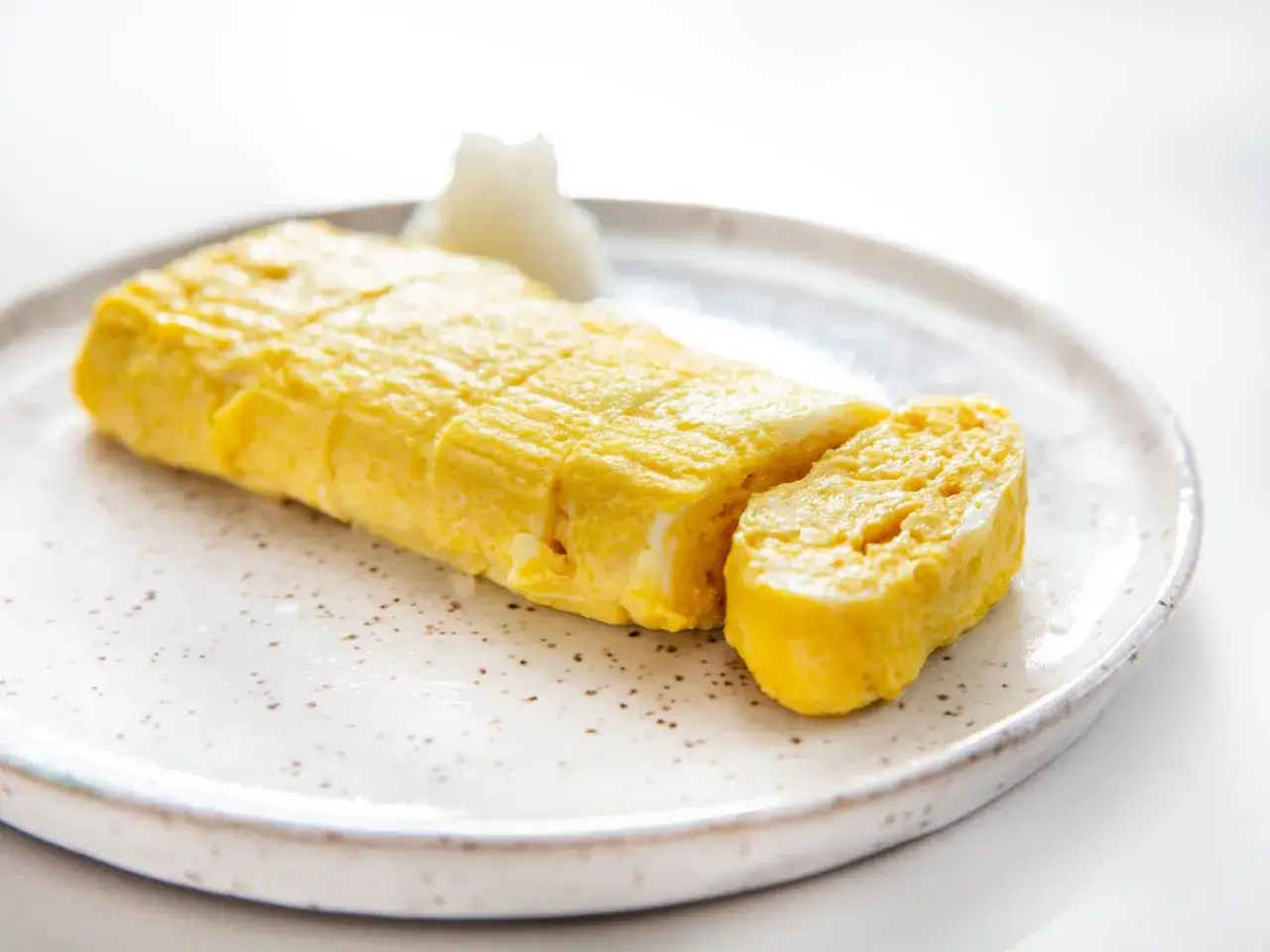 Tamago to japoński omlet, delikatnie zwinięty i pokrojony. Idealny na śniadanie lub jako dodatek.