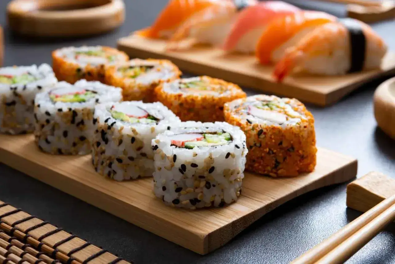 Uranaki sushi na drewnianej desce, obok nigiri z łososiem i krewetką. Smaczna uczta!