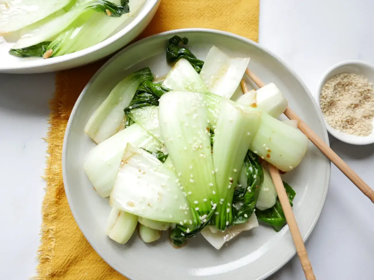Pyszna sałata pak choi, polana sosem i posypana sezamem, gotowa do jedzenia pałeczkami.