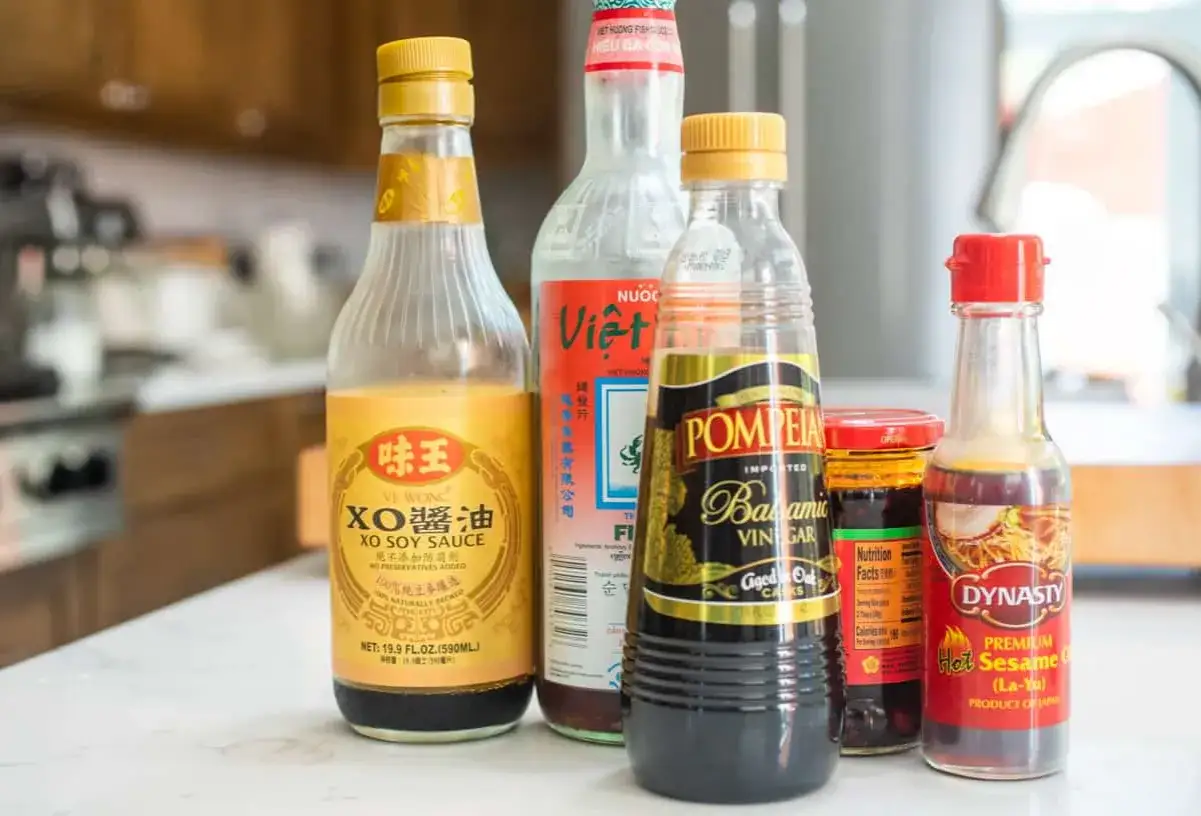 Butelki sosu sojowego XO, sosu rybnego, octu balsamicznego i oleju sezamowego – składniki, które nadadzą potrawom głęboki smak umami.