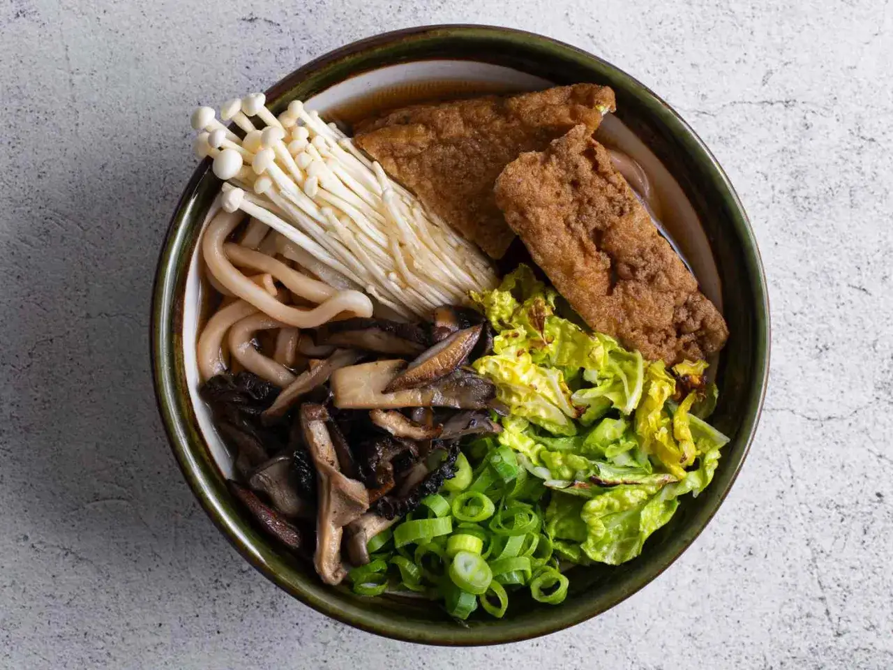 Miseczka z makaronem udon, grzybami enoki, shiitake, smażonym tofu i warzywami. Zdrowe danie, które warto znać pod kątem makaron udon kcal.