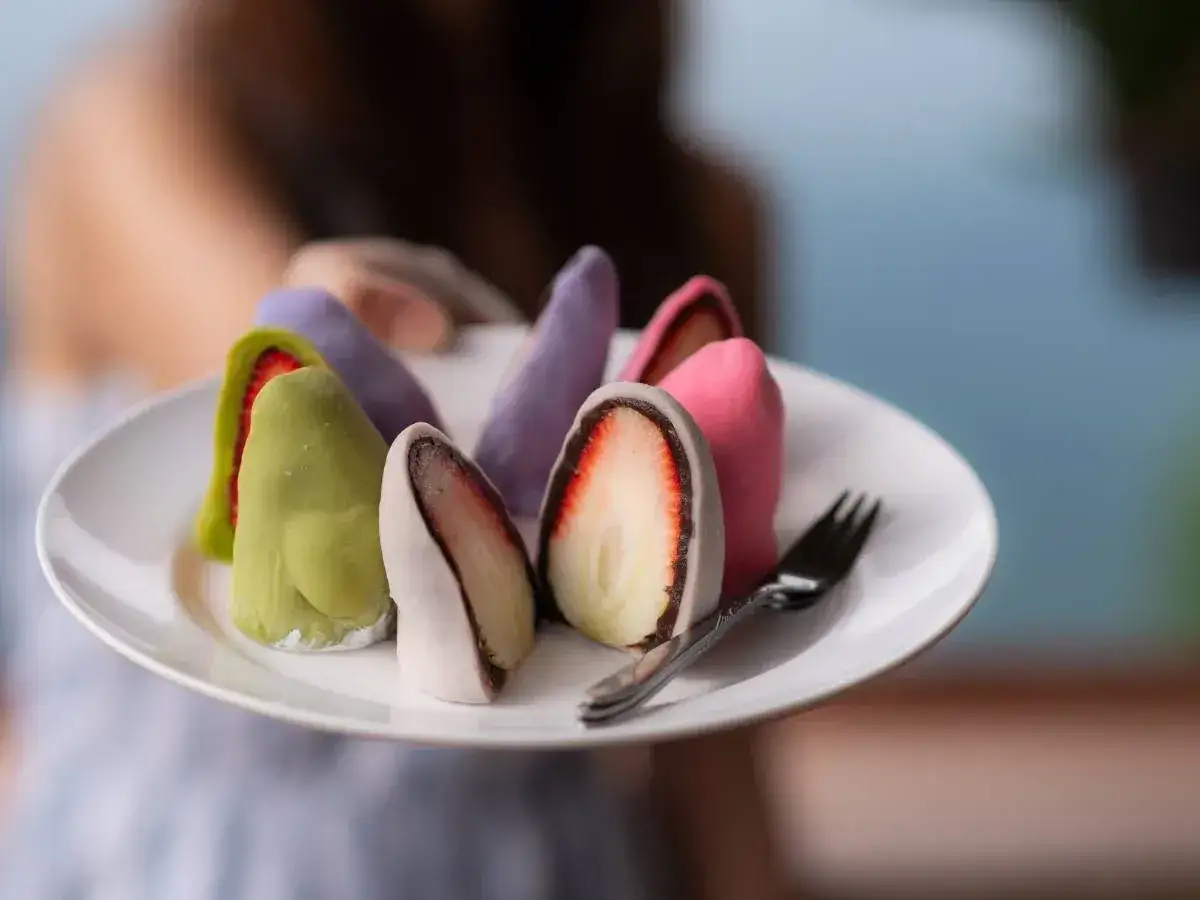 Kolorowe mochi z truskawkami na talerzu. Chcesz wiedzieć, jak zrobić mochi?