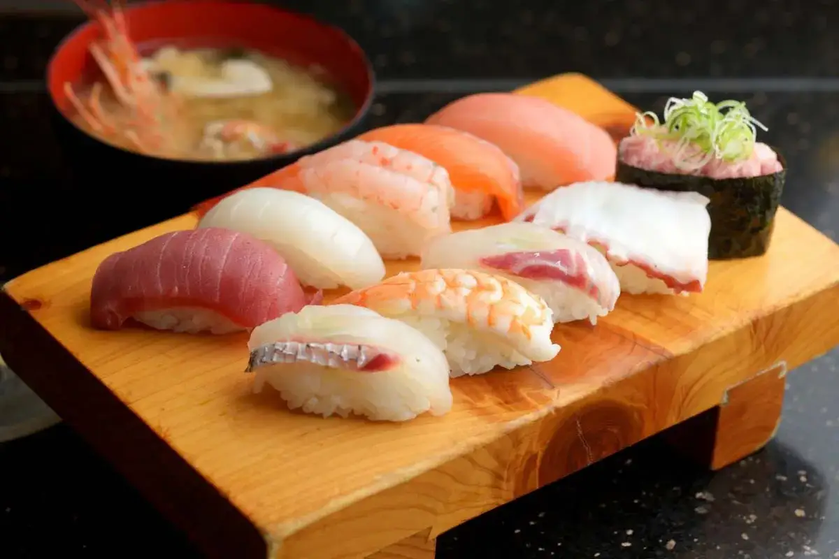 Pyszne sushi z tuńczykiem, łososiem, krewetkami i kalmarem, podane z miseczką zupy miso. Idealne do sushi jest odrobina wasabi.