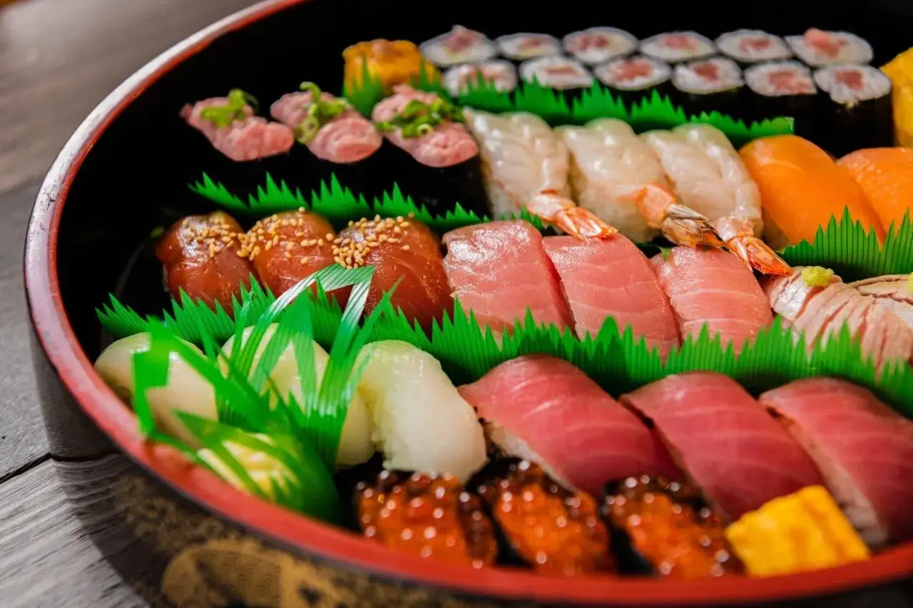 Talerz pełen różnorodnego sushi: nigiri z łososiem, tuńczykiem, krewetkami, makami, ikrą i tamago. To właśnie sushi, czyli japońska uczta dla oczu i podniebienia.