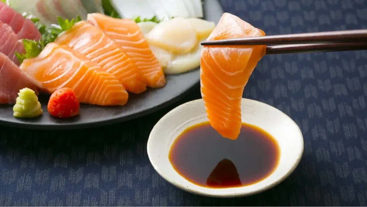 Sashimi z łososia i tuńczyka, pałeczkami zanurzane w sosie sojowym fodmap.