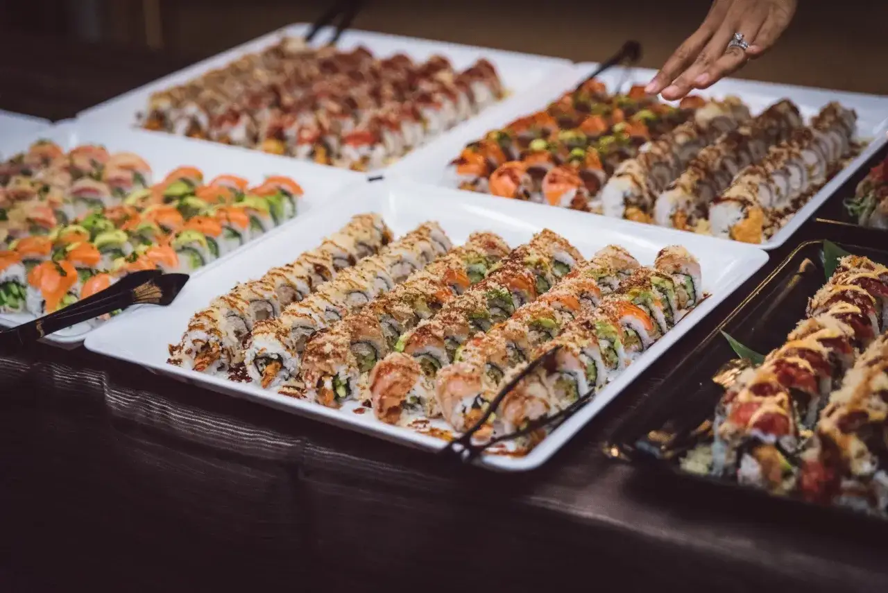 Różne rodzaje sushi nazwy: maki z łososiem i awokado, rolki z chrupiącą panierką i polewą.