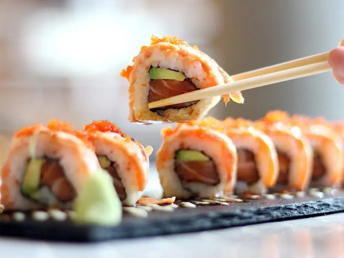 Smaczne sushi z łososiem i awokado, posypane ikrą. Zastanawiasz się nad sushi kalorie?