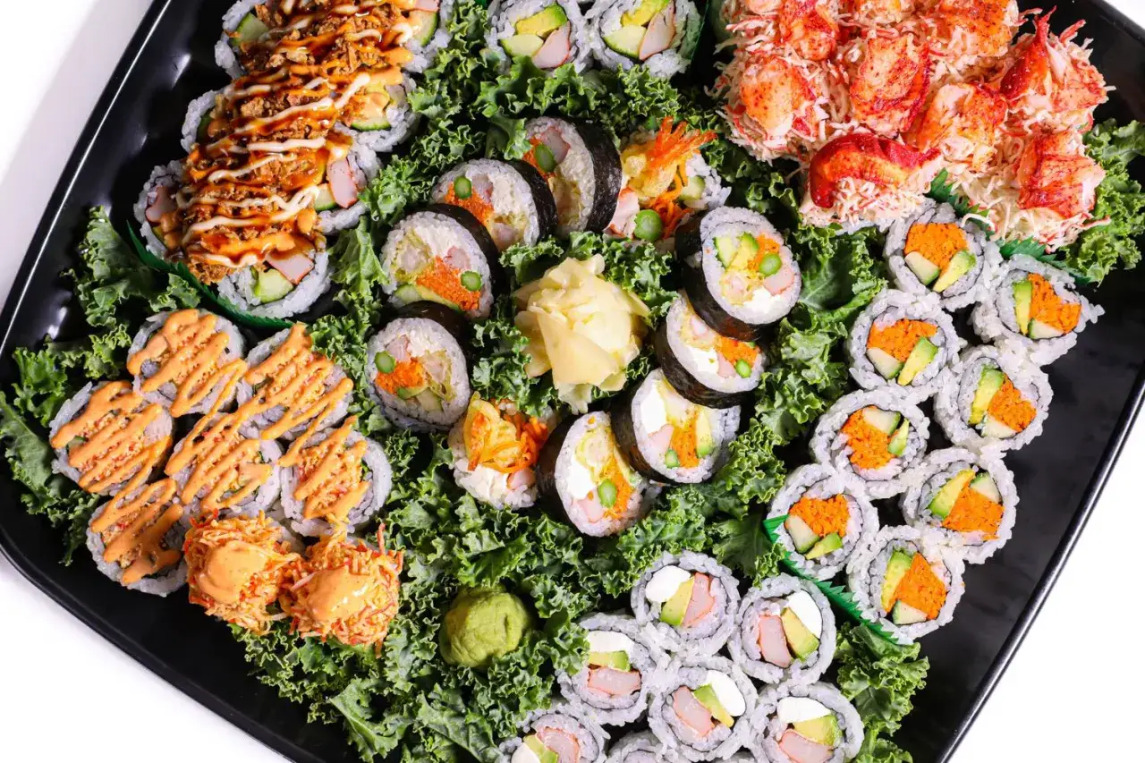 Talerz sushi z różnymi rolkami, w tym z krewetkami i awokado. Zastanawiasz się, ile waży rolka sushi?