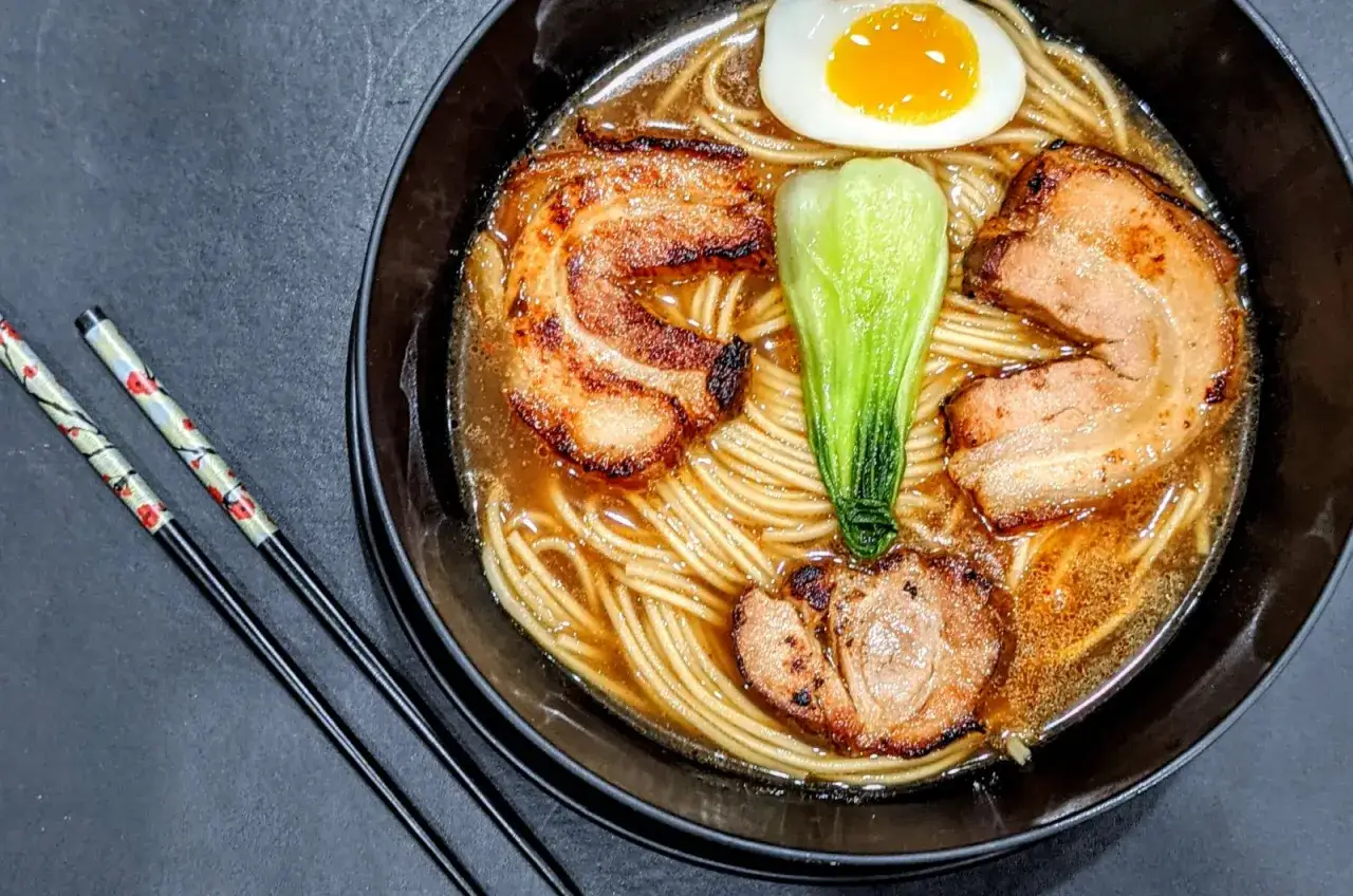 Aksamitny bulion, delikatny makaron i soczyste plastry wieprzowiny tworzą idealny ramen z wieprzowiną. Jajko i pak choi dodają koloru.