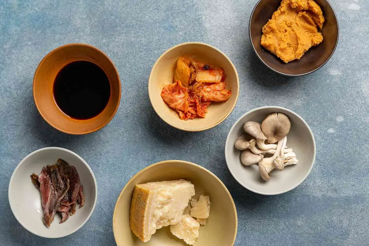 Miseczki z sosem sojowym, kimchi, grzybami ostrygowymi, parmezanem, anchois i pastą miso – składniki, które mają smak umami.