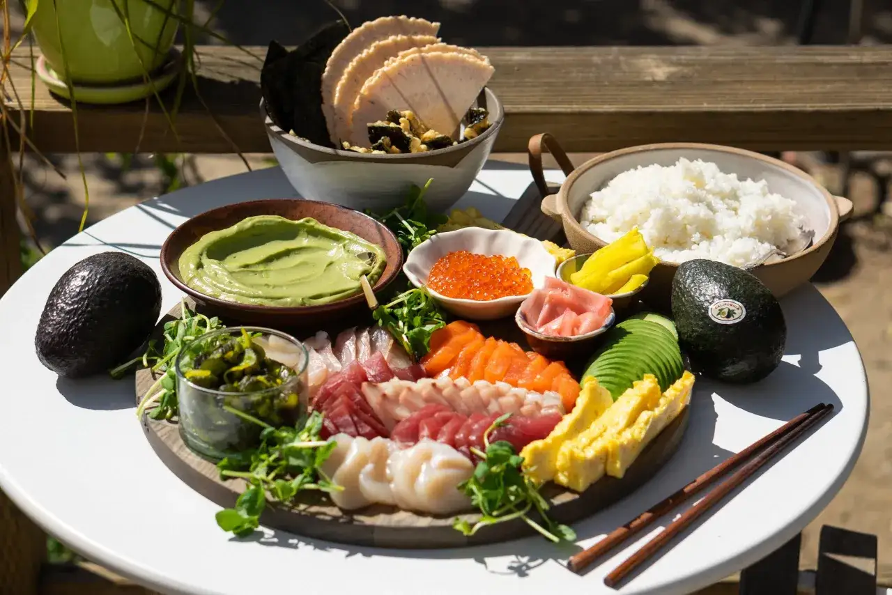 Piękne dodatki do sushi: świeże ryby, awokado, ryż, ikra, nori i sos. Idealne na letni posiłek.